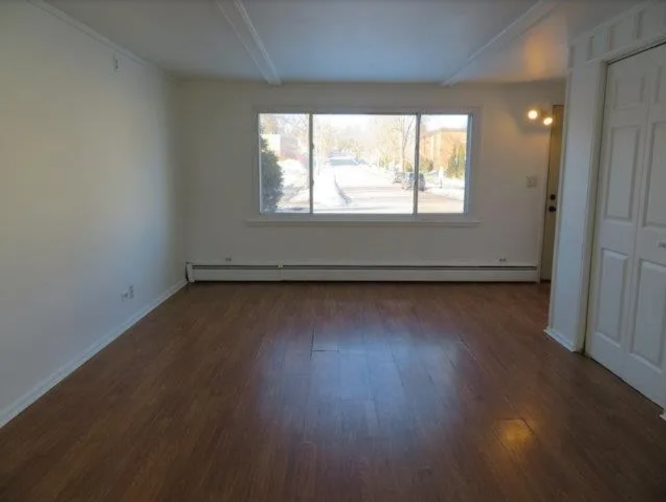Empty room with wooden floor and white walls.