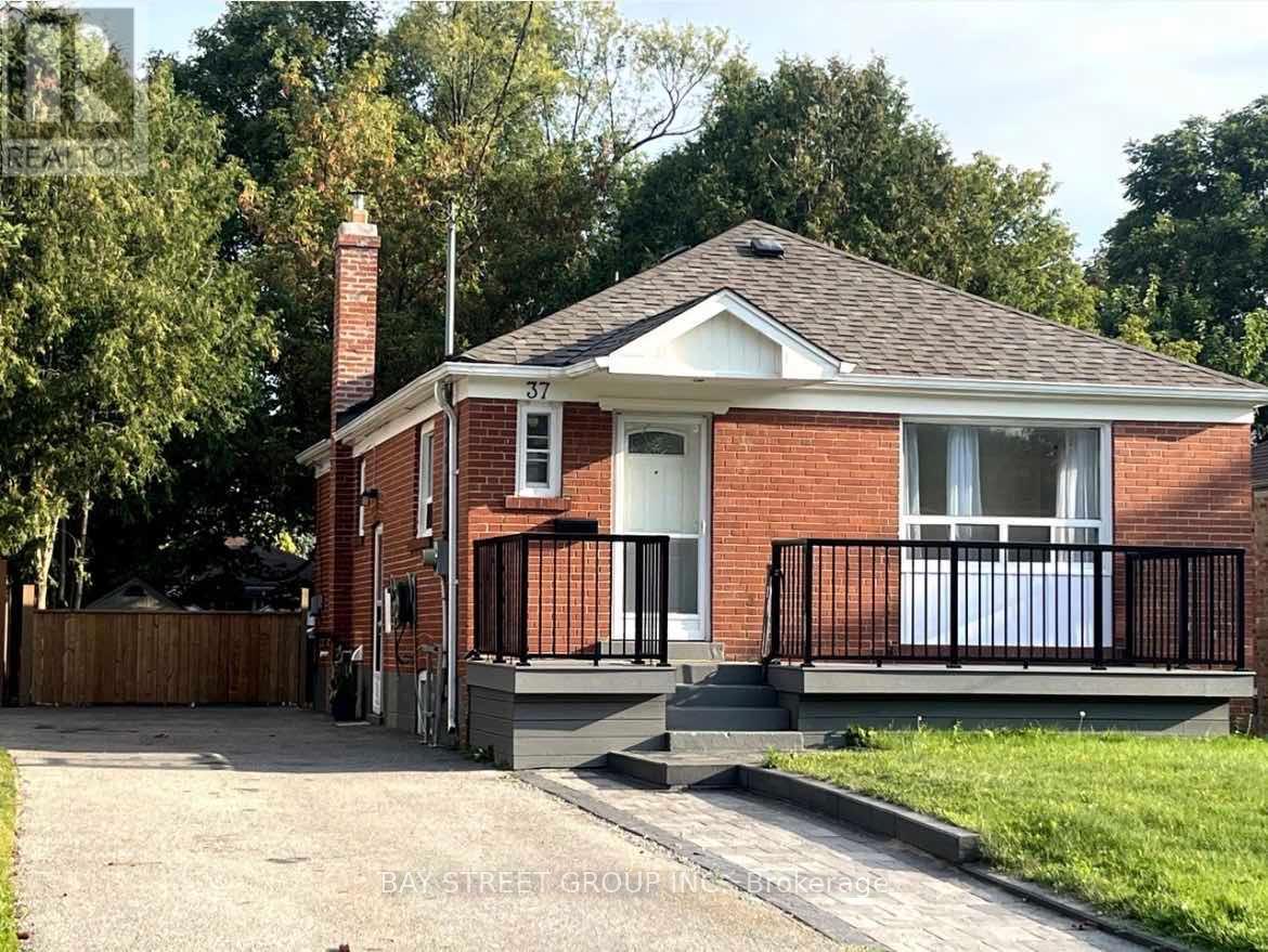 A red brick house with a black fence and a white door.