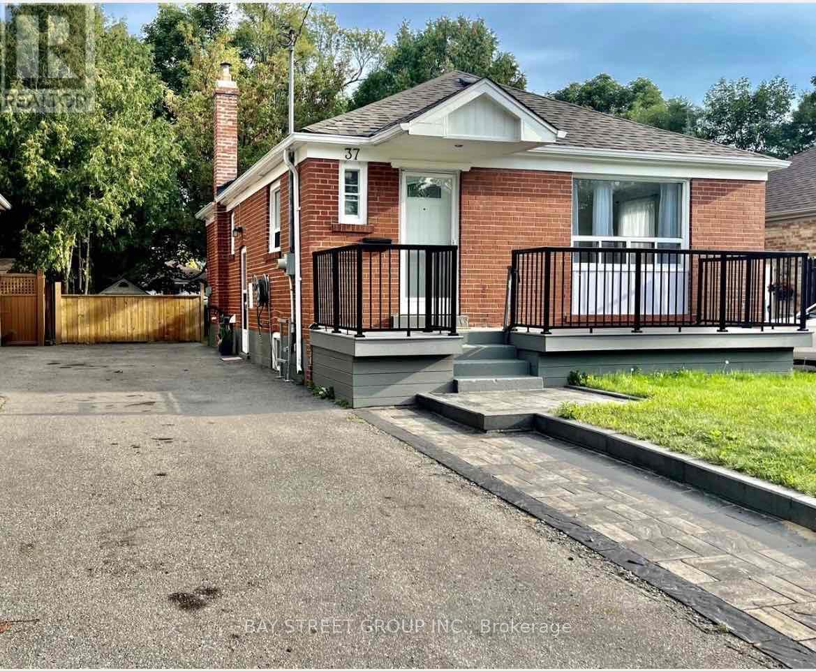 A red brick house with a black fence and a white door.