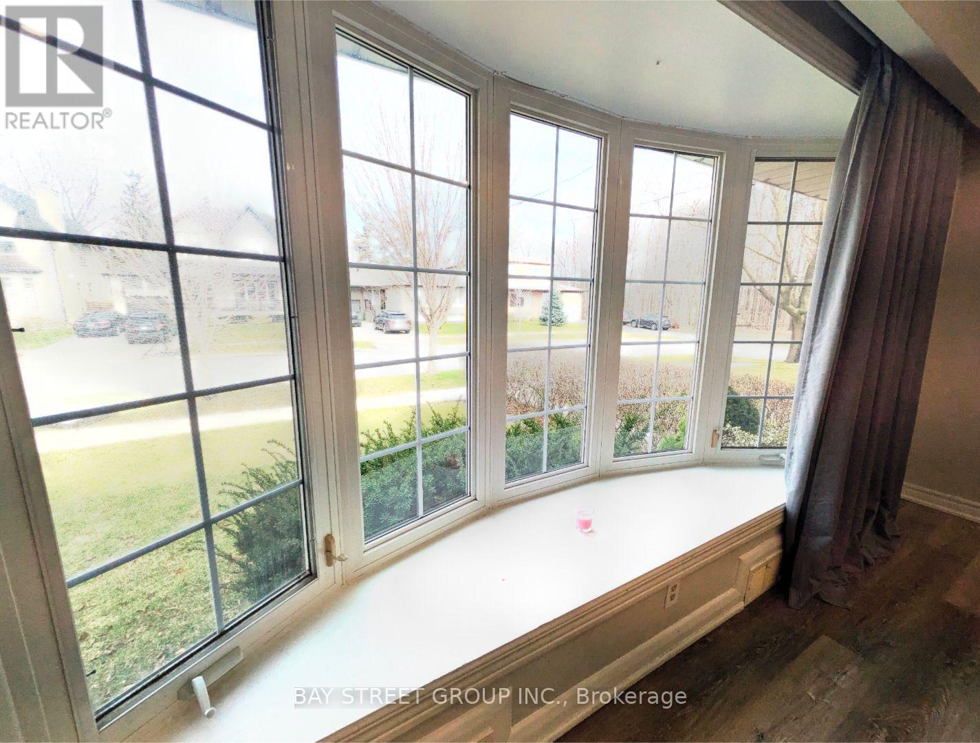 A room with a large window overlooking a street.