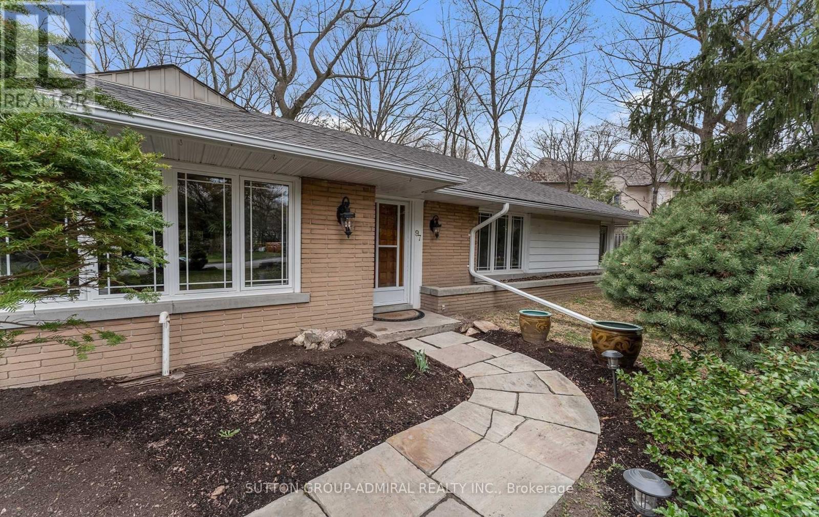 A house with a brown front yard and a stone pathway leading to the front door.