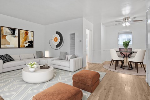 A living room with a white couch, a round coffee table, and a dining table with chairs.