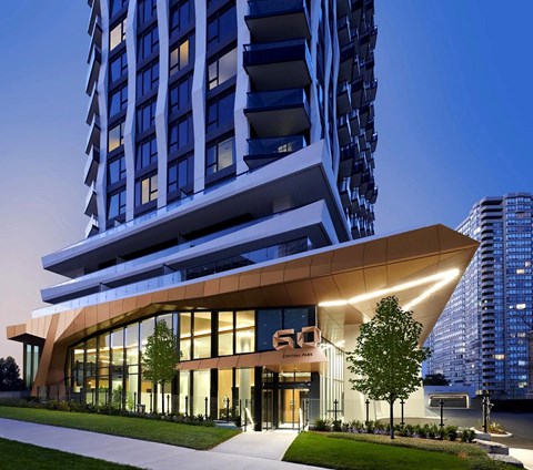 A modern building with a curved glass facade and a number 50 on it.