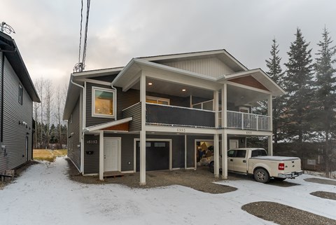 A modern house with a white truck parked in front.