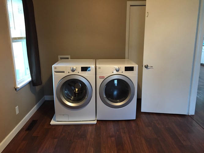 Two front load washing machines in a laundry room.