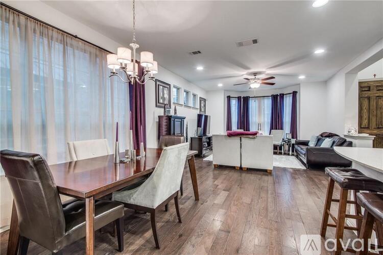A well-lit dining room with a wooden table and chairs.