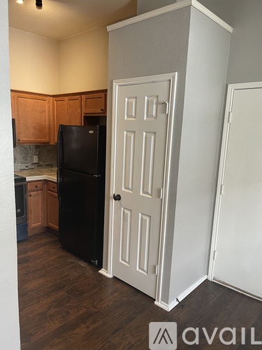 A kitchen with a black fridge and white door.