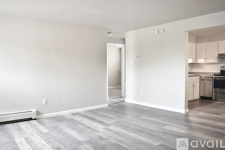 A spacious room with a grey floor and white walls.