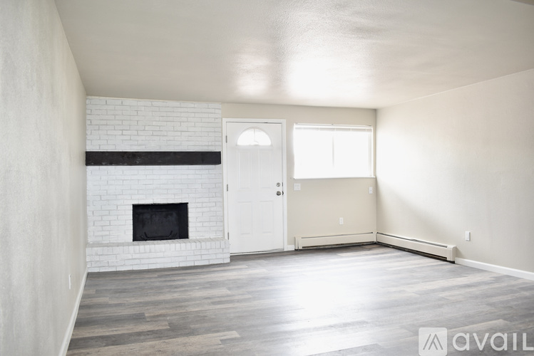 A room with a white brick fireplace and a white door.