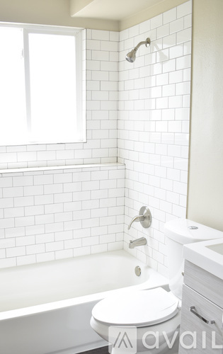 A white toilet in a bathroom with a white tiled wall.