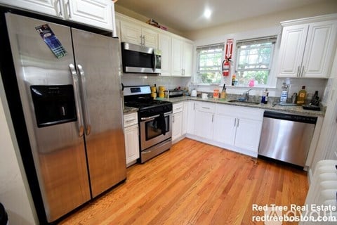 A kitchen with wooden floors and stainless steel appliances.