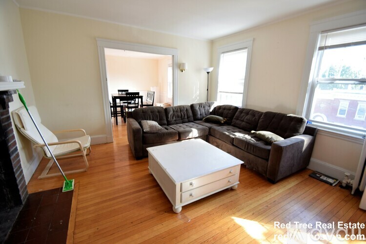 A living room with a white coffee table and brown couches.