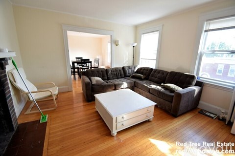A living room with a white coffee table and brown couches.