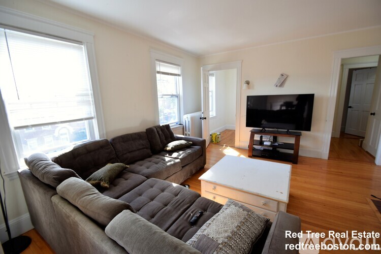 A living room with a grey couch and a white coffee table.