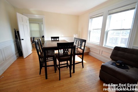 A dining room with a wooden table and chairs.