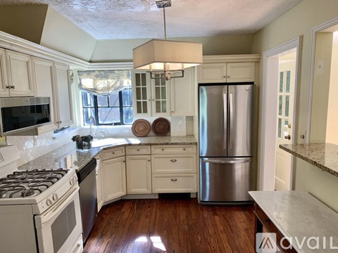 A kitchen with a stove top oven and a refrigerator.
