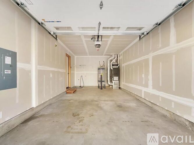 A spacious, empty room with white walls and a concrete floor.