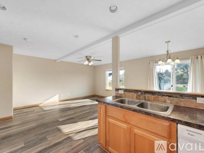 A kitchen with a wooden counter and a window with curtains.