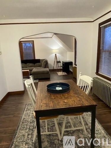 A dining room with a wooden table and chairs.