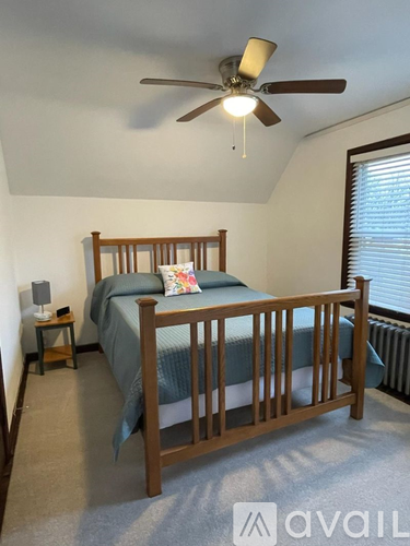 A bedroom with a bed, nightstand, and window.