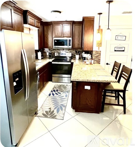 A kitchen with a granite counter top and a refrigerator.