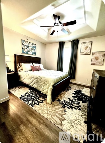 A bedroom with a bed, a ceiling fan, and a rug.