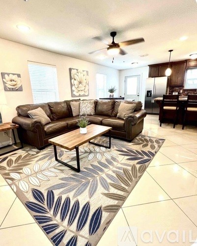 A living room with a brown sofa and a patterned rug.
