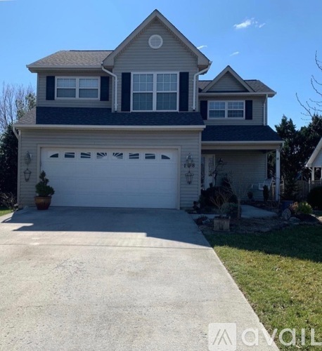 A two-story house with a garage and a driveway.