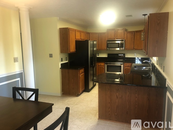 A kitchen with wooden cabinets and black appliances.
