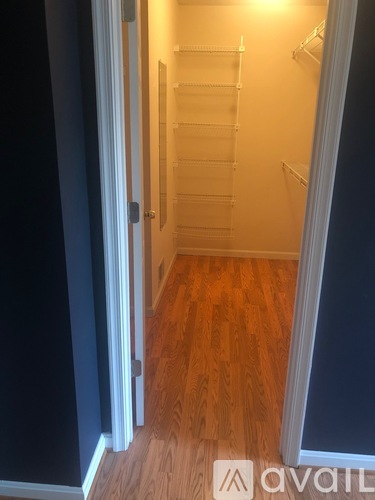 A hallway with a wooden floor and white walls.