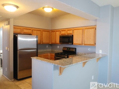 A kitchen with a refrigerator, microwave, and oven.
