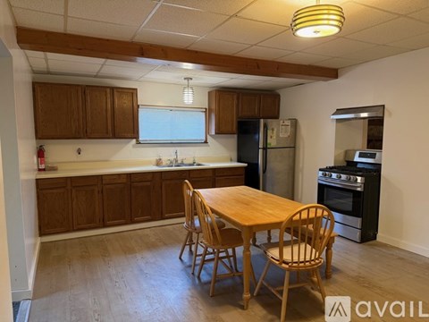 A kitchen with wooden cabinets and a table with chairs.