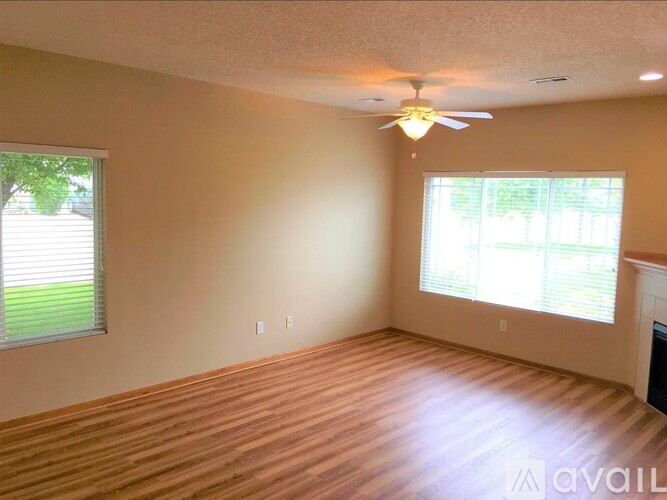 A room with a ceiling fan and a window with blinds.