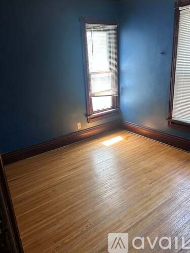 A room with wooden flooring and a window.