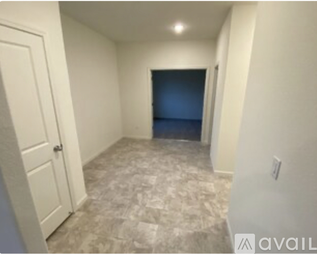 A room with a carpeted floor and a door on the left.