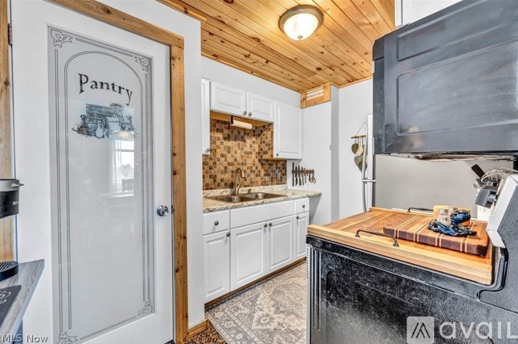A kitchen with a pantry door and a black stove top oven.