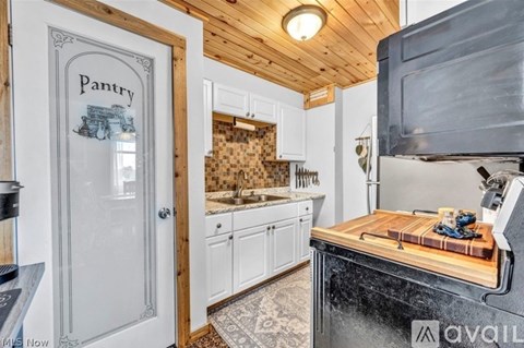 A kitchen with a pantry door and a black stove top oven.