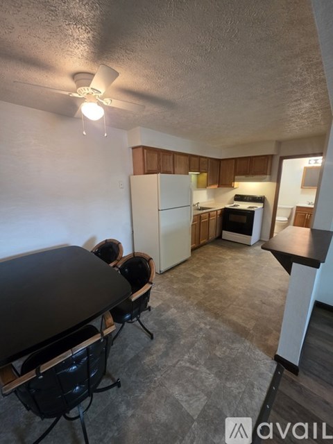 A kitchen area with a table and chairs.