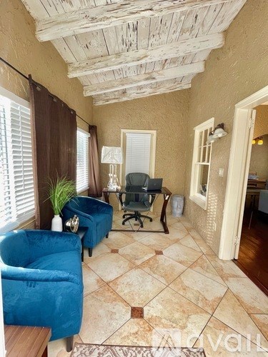 A living room with a blue couch and a wooden floor.