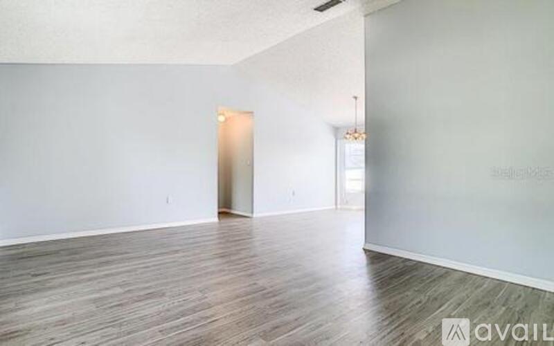A room with wooden flooring and a white wall.