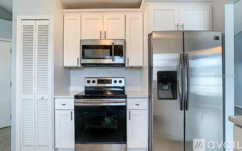 A kitchen with white cabinets and stainless steel appliances.