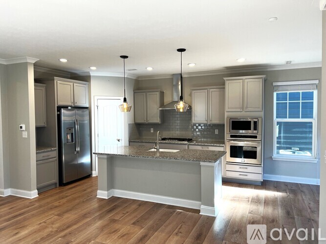 A kitchen with a refrigerator, oven, and sink.