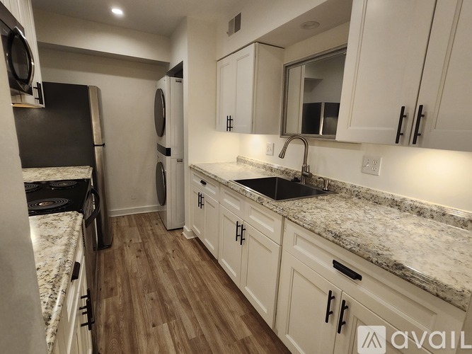 A kitchen with white cabinets and a granite countertop.