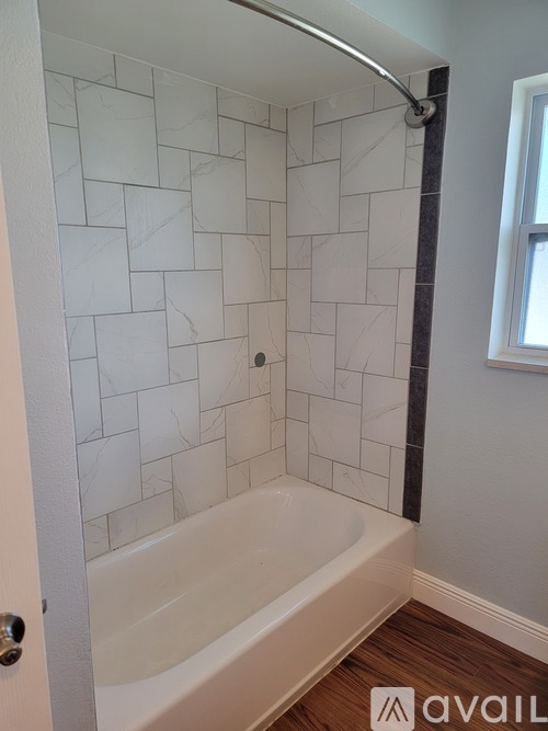 A bathroom with a white tiled shower and a white bathtub.