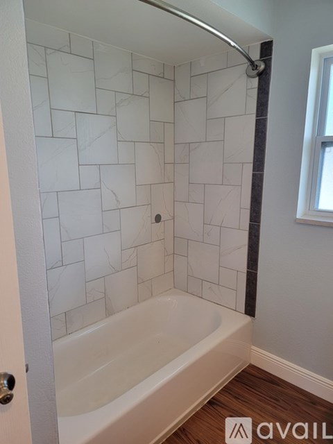 A bathroom with a white tiled shower and a white bathtub.
