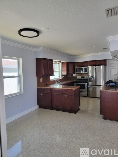 A kitchen with a large island and stainless steel appliances.