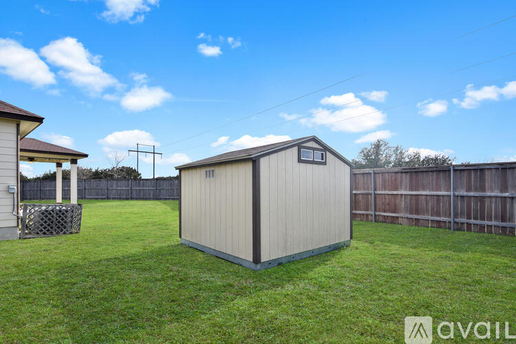 A shed sits in a grassy backyard.