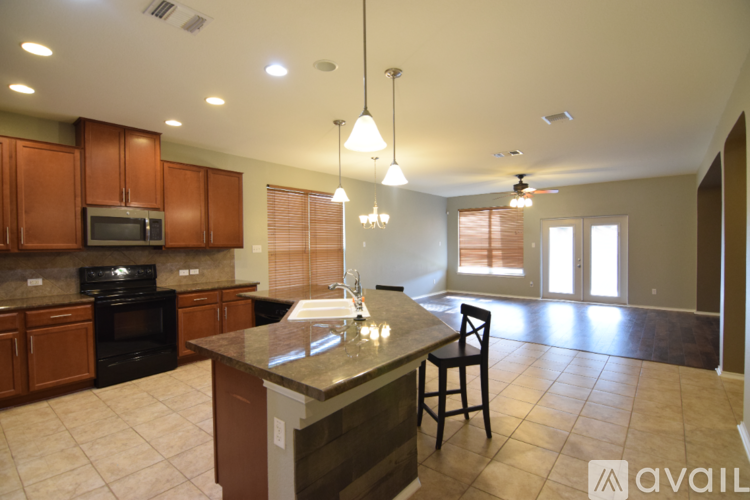 A kitchen with brown cabinets and a granite countertop.