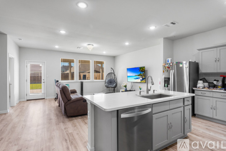 A modern kitchen with a large island and a refrigerator.
