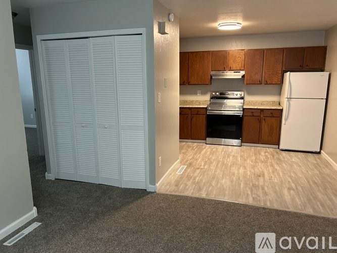 A kitchen with a white refrigerator and wooden cabinets.